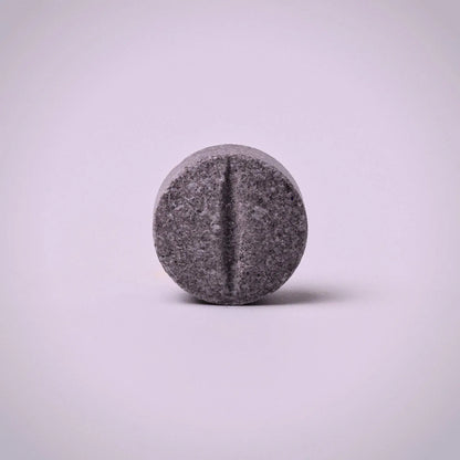 Gray 7ohBLACK 7-oh pill-like object on a light purple background