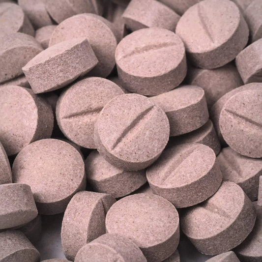 Close-up of a pile of gray 7ohBLACK 7-oh tablets